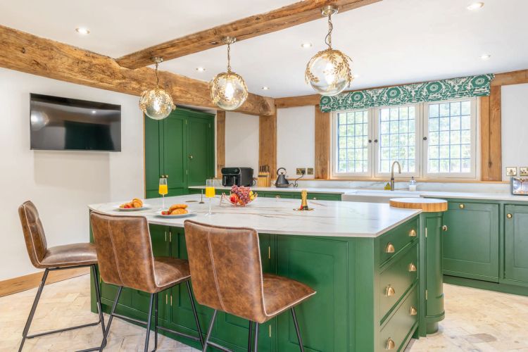 Modern kitchen at Porters Hall featuring a traditional Aga cooker, American-style fridge freezer, and a central breakfast island.