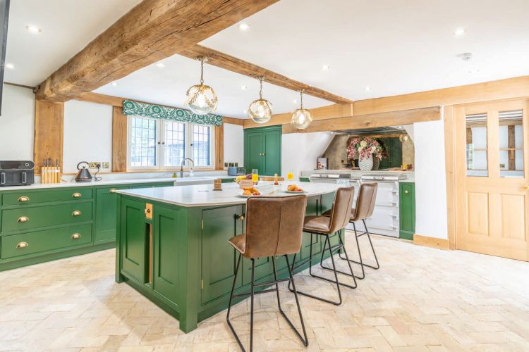 Modern kitchen at Porters Hall featuring a traditional Aga cooker, American-style fridge freezer, and a central breakfast island.