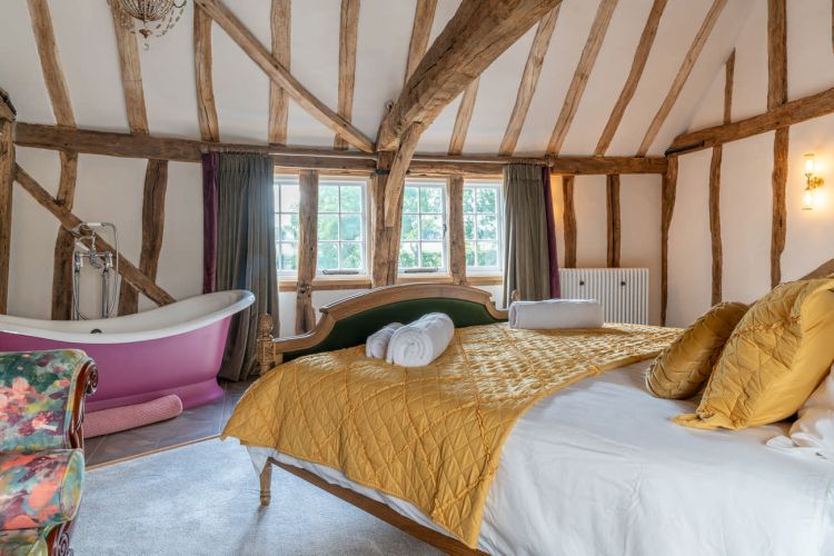 Luxury bedroom in the main house at Porters Hall featuring a four-poster bed and high-quality white linens.
