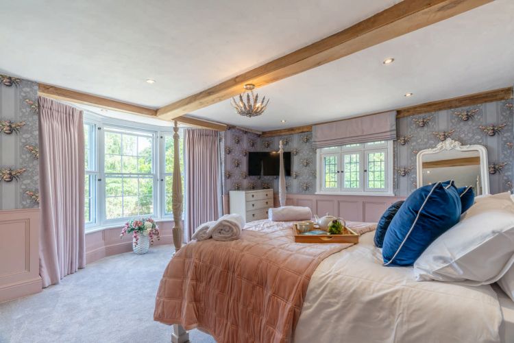 Luxury bedroom in the main house at Porters Hall featuring a four-poster bed and high-quality white linens.