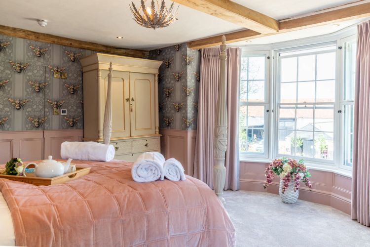 Luxury bedroom in the main house at Porters Hall featuring a four-poster bed and high-quality white linens.