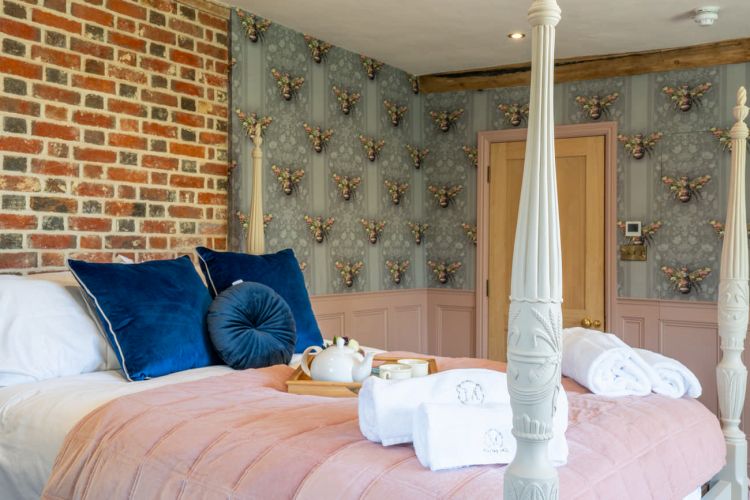 Luxury bedroom in the main house at Porters Hall featuring a four-poster bed and high-quality white linens.
