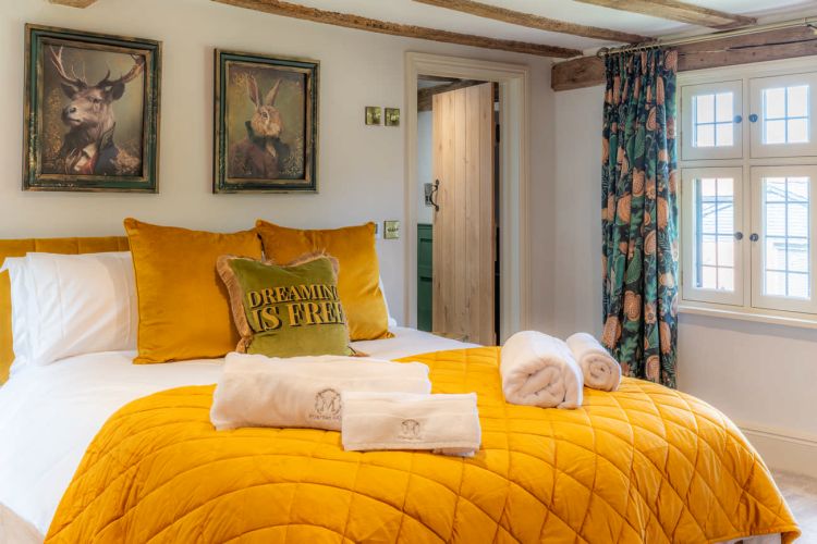 Luxury bedroom in the main house at Porters Hall featuring a four-poster bed and high-quality white linens.