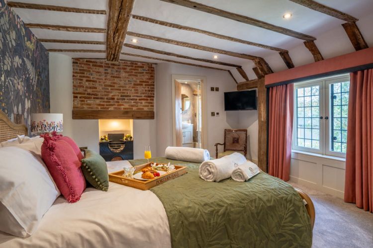 Luxury bedroom in the main house at Porters Hall featuring a four-poster bed and high-quality white linens.