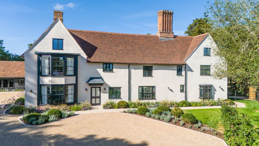 Aerial view of Porters Hall, a historic Grade II listed manor house surrounded by a medieval water moat and lush green Essex countryside