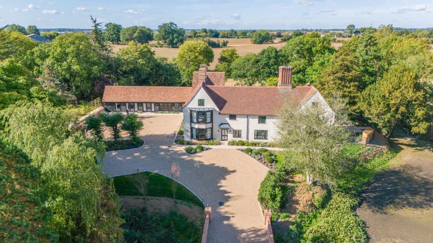 Aerial view of Porters Hall, a historic Grade II listed manor house surrounded by a medieval water moat and lush green Essex countryside