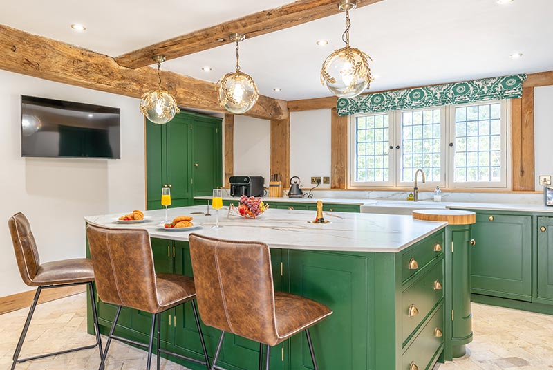 Modern kitchen at Porters Hall featuring a traditional Aga cooker, American-style fridge freezer, and a central breakfast island.